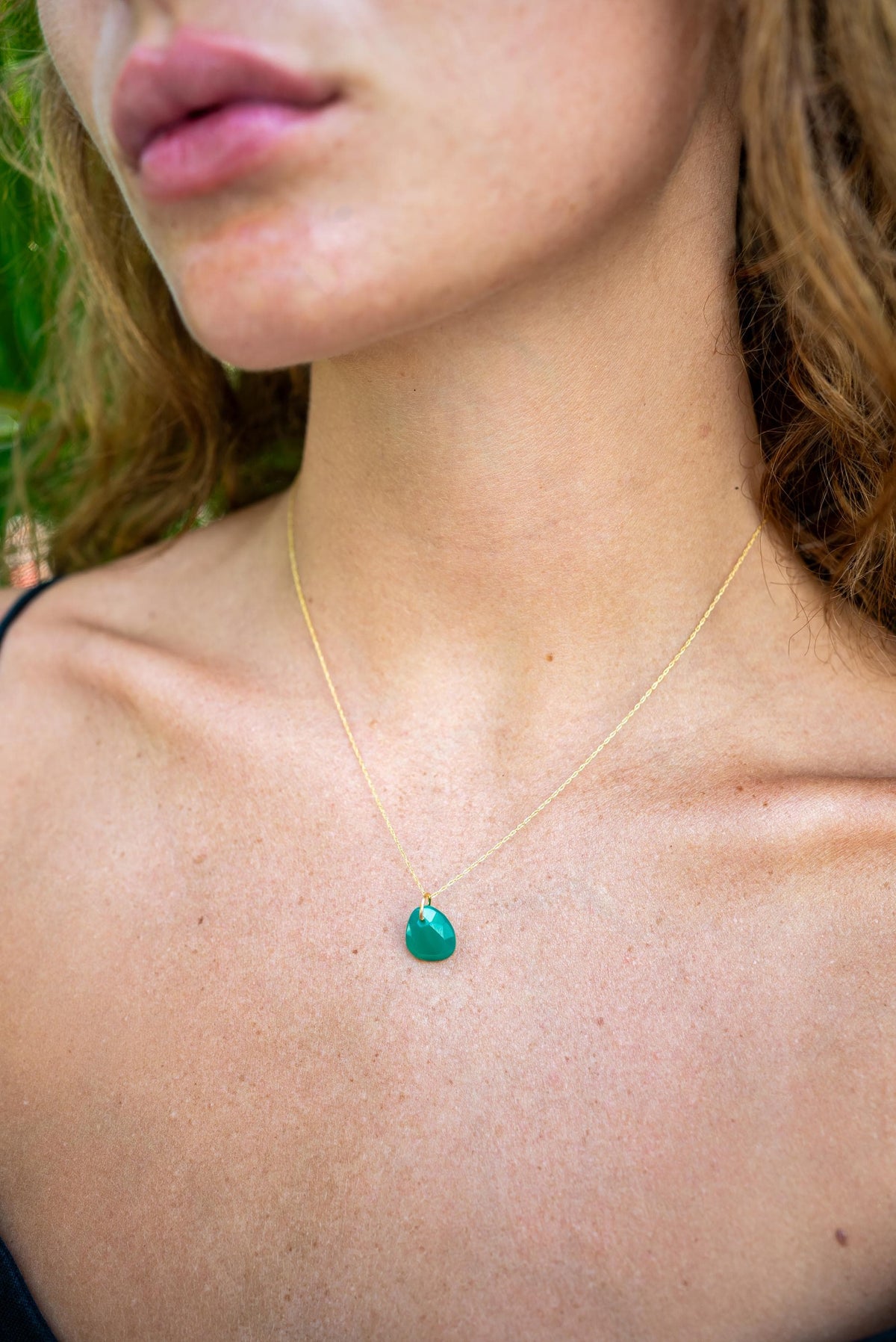 Green onyx pendant in 14K gold setting with a polished finish, featuring a vibrant green gemstone on a delicate chain.
