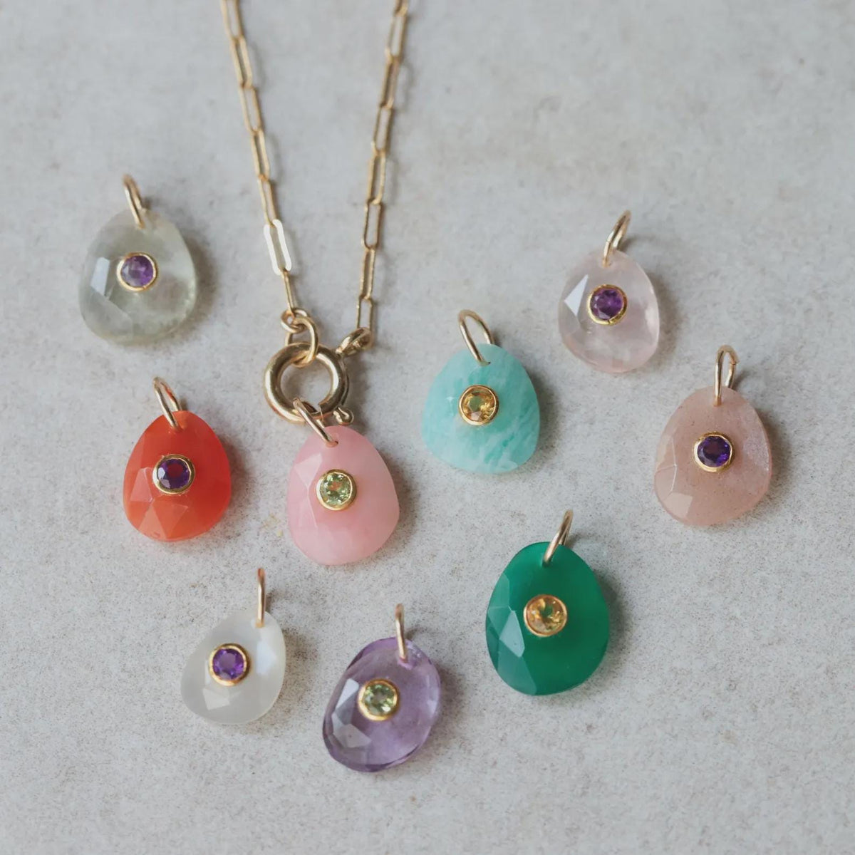 Pink Opal and Peridot pendant from Earthly Abundance featuring a blush bloom design, showcased against a neutral background.