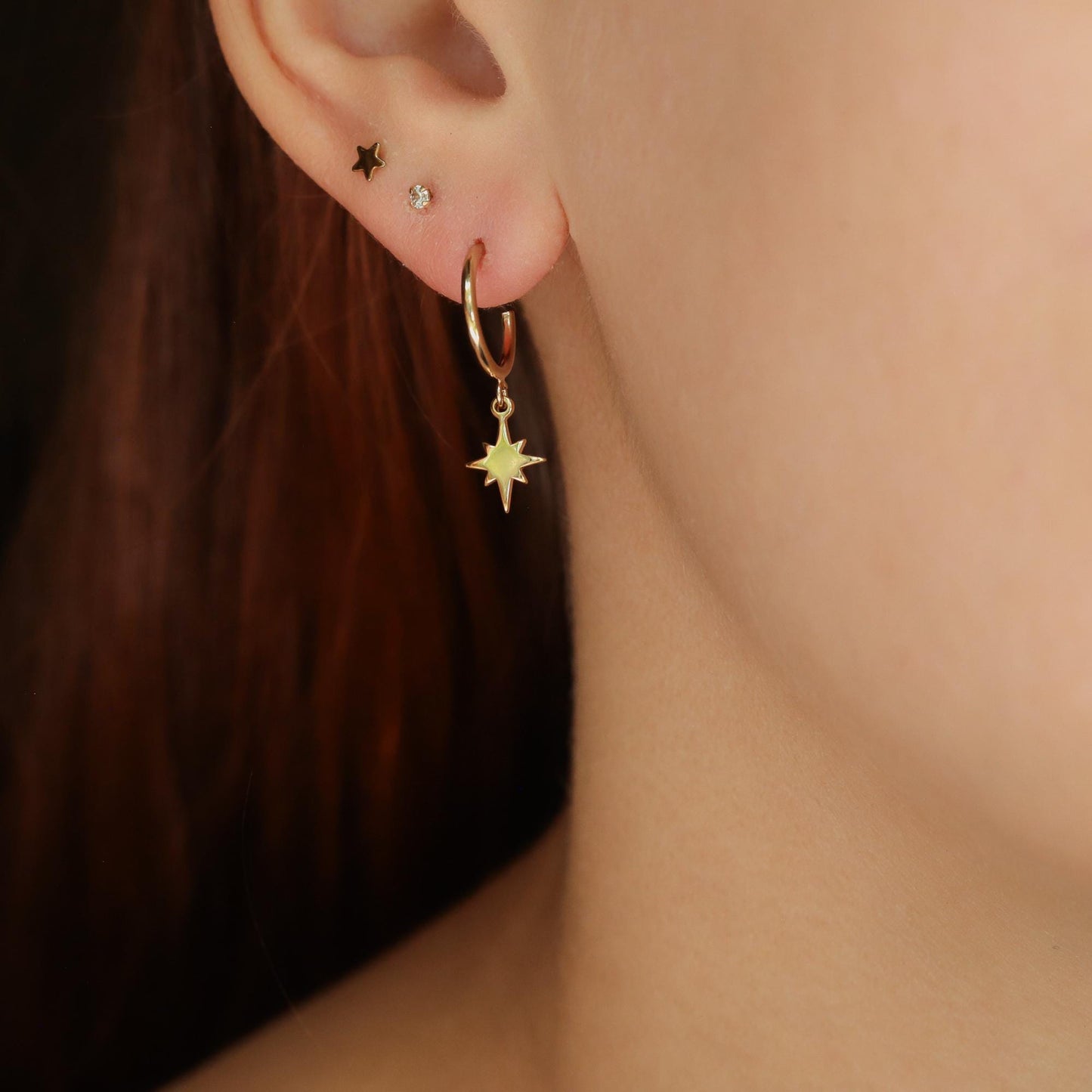 14K gold filled North Star Hoop Earrings by Earthly Abundance, featuring shiny gold hoops with star charms, stylish and elegant.