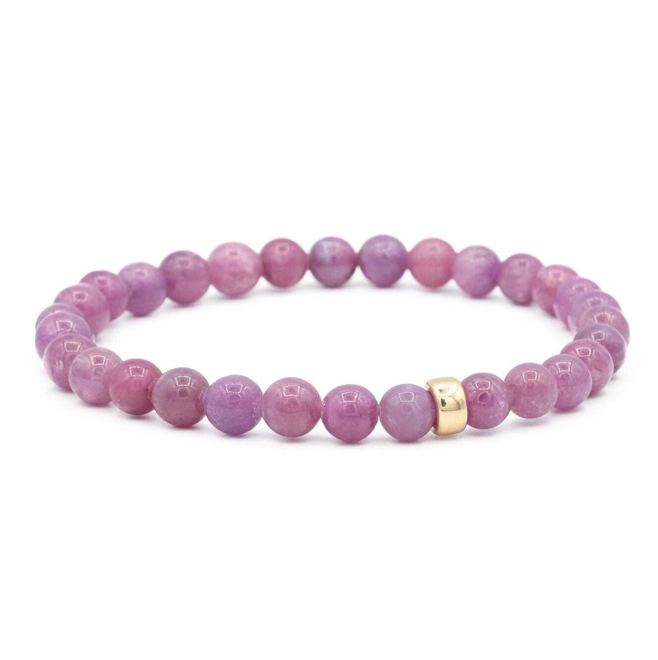 Earthly Abundance Gemma Ruby Bracelet featuring vibrant red rubies and delicate gold chain on a neutral background.