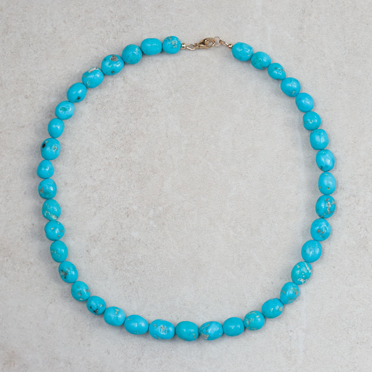 14K Sleeping Beauty turquoise pendant by Earthly Abundance featuring a vibrant turquoise gemstone in a gold setting.