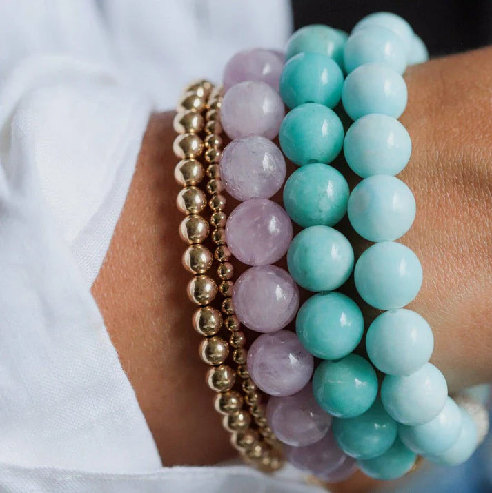 Kunzite bracelet with 10mm beads from Earthly Abundance Jewelry, featuring soft pink-purple gemstones on a delicate string.