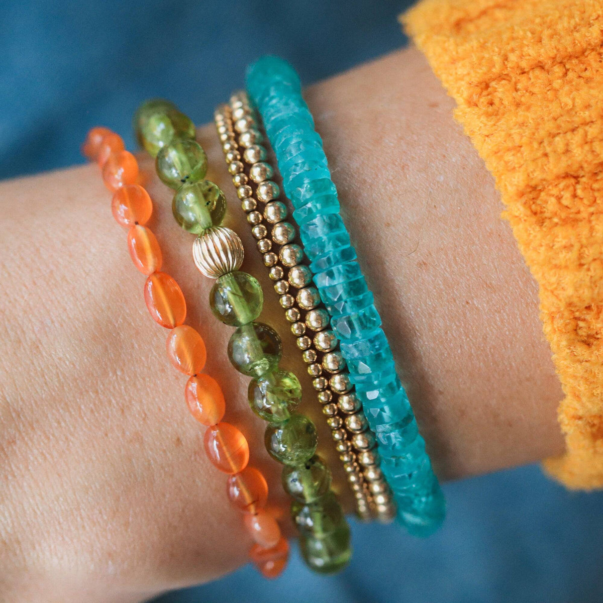 Earthly Abundance Carnelian nugget bracelet featuring polished orange-red stones on an elastic band, close-up view of the jewelry.