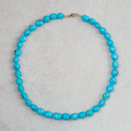 14K Sleeping Beauty turquoise pendant by Earthly Abundance featuring a vibrant turquoise gemstone in a gold setting.