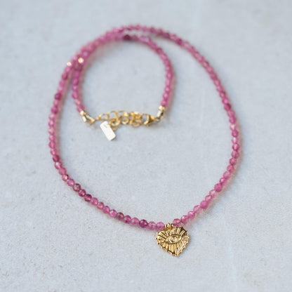 Pink tourmaline evil eye heart pendant from Earthly Abundance featuring a vibrant pink gemstone and protective evil eye design.