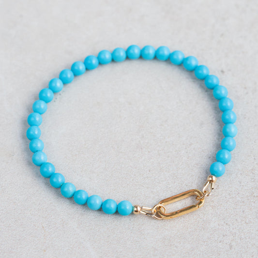 14K Sleeping Beauty Carabiner Bracelet by Earthly Abundance featuring a gold-toned carabiner clasp and Sleeping Beauty turquoise charm.