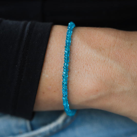 A 14K gold apatite bracelet with polished blue-green gemstone beads, displayed on a neutral background.
