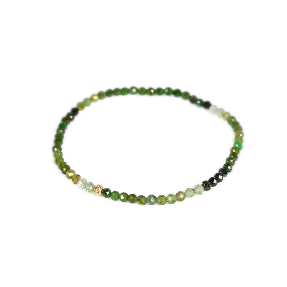 Green Tourmaline gemstone in 14K gold setting, showcasing vibrant green color and polished finish.