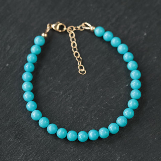 Adjustable Sleeping Beauty turquoise pendant in 14K gold with detailed setting, showcasing vibrant blue gemstone and fine craftsmanship.