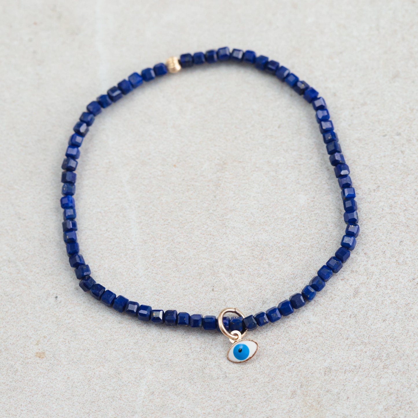 Lapis Lazuli Evil Eye pendant in 14K gold from Earthly Abundance, featuring a vibrant blue gemstone with gold accents.