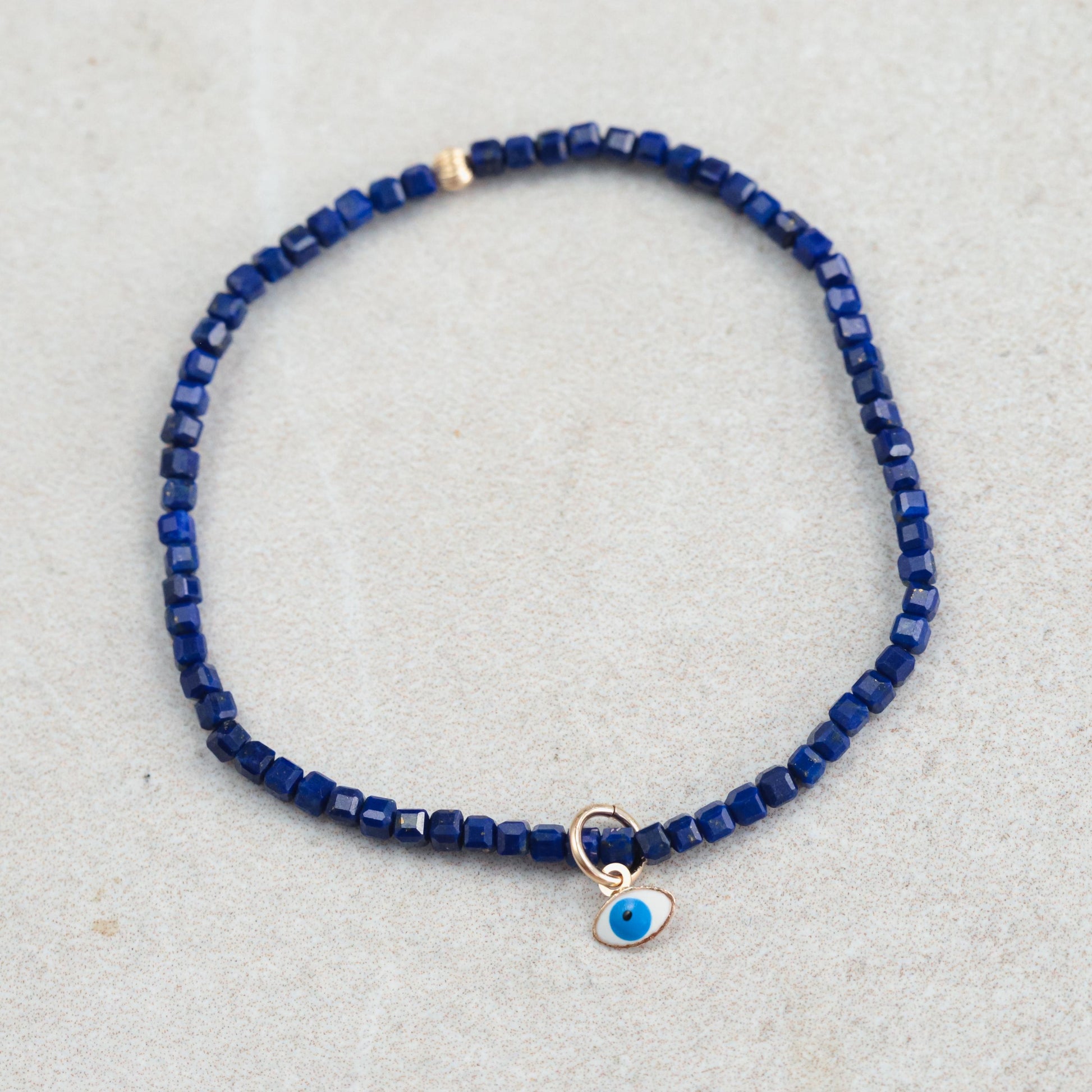 Lapis Lazuli Evil Eye pendant in 14K gold from Earthly Abundance, featuring a vibrant blue gemstone with gold accents.