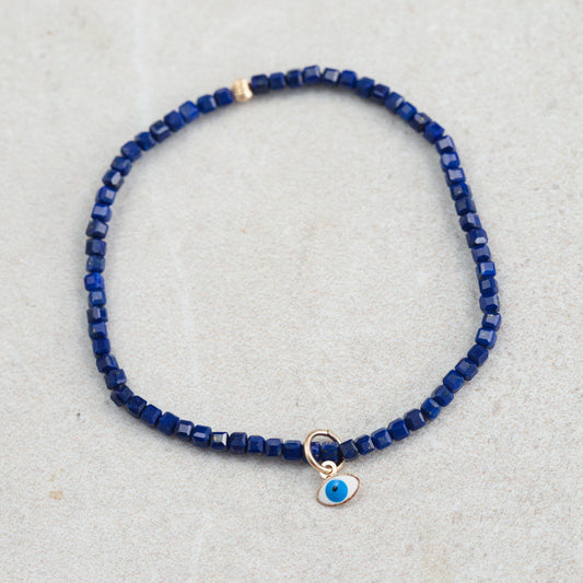 Lapis Lazuli Evil Eye pendant in 14K gold from Earthly Abundance, featuring a vibrant blue gemstone with gold accents.