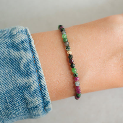 Ruby Zoisite 3mm gemstone beads from Earthly Abundance, showcasing vibrant red and green mineral colors on a string.