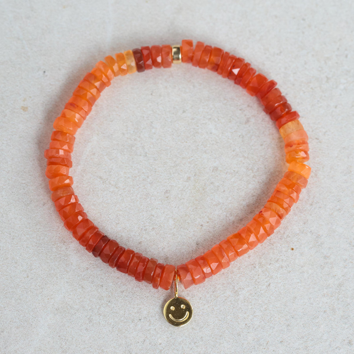 Genuine Carnelian Smily pendant in 14K gold from Earthly Abundance, featuring a vibrant orange gemstone with a playful smile design.