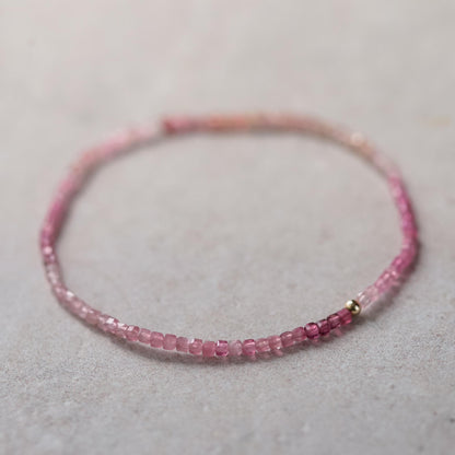 Pink tourmaline cube bracelet made with 14K gold, featuring vibrant pink gemstone beads on a delicate gold chain.