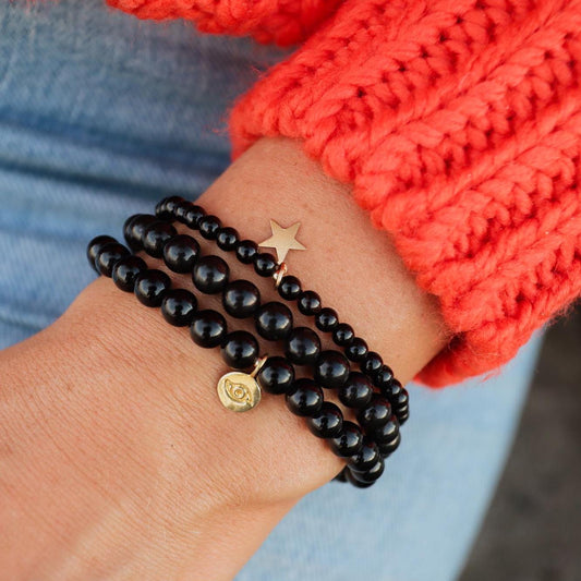 Shungite beads in 4mm, 6mm, or 8mm size with 14K gold accents from Earthly Abundance, showcasing polished black stones.