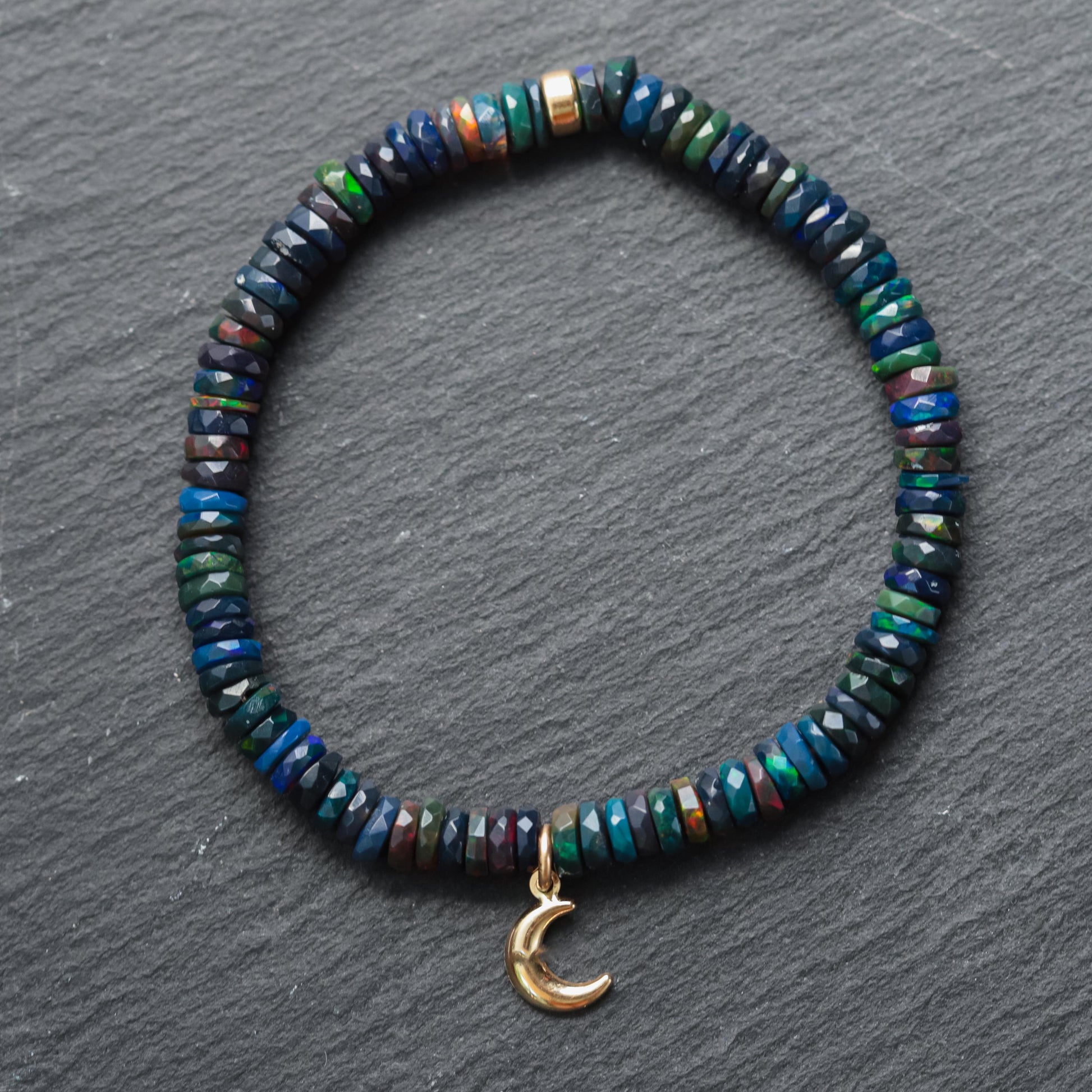 Black Opal Moon bracelet with 14K gold accents from Earthly Abundance, featuring a luminous moon-shaped opal pendant.