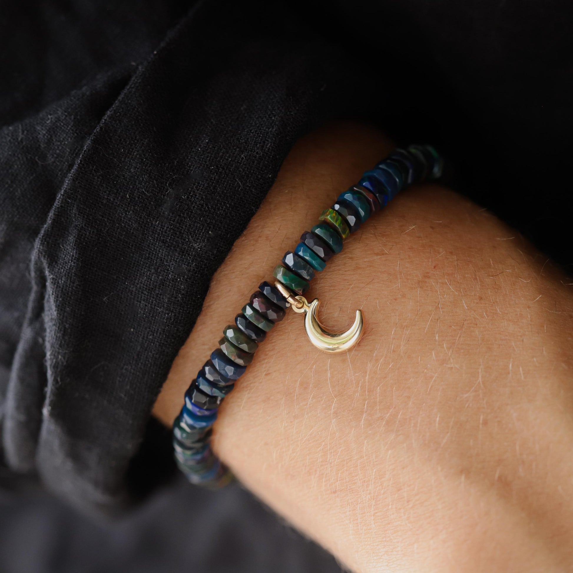 Black Opal Moon bracelet with 14K gold setting from Earthly Abundance, featuring a celestial moon design and vibrant opal gemstone.