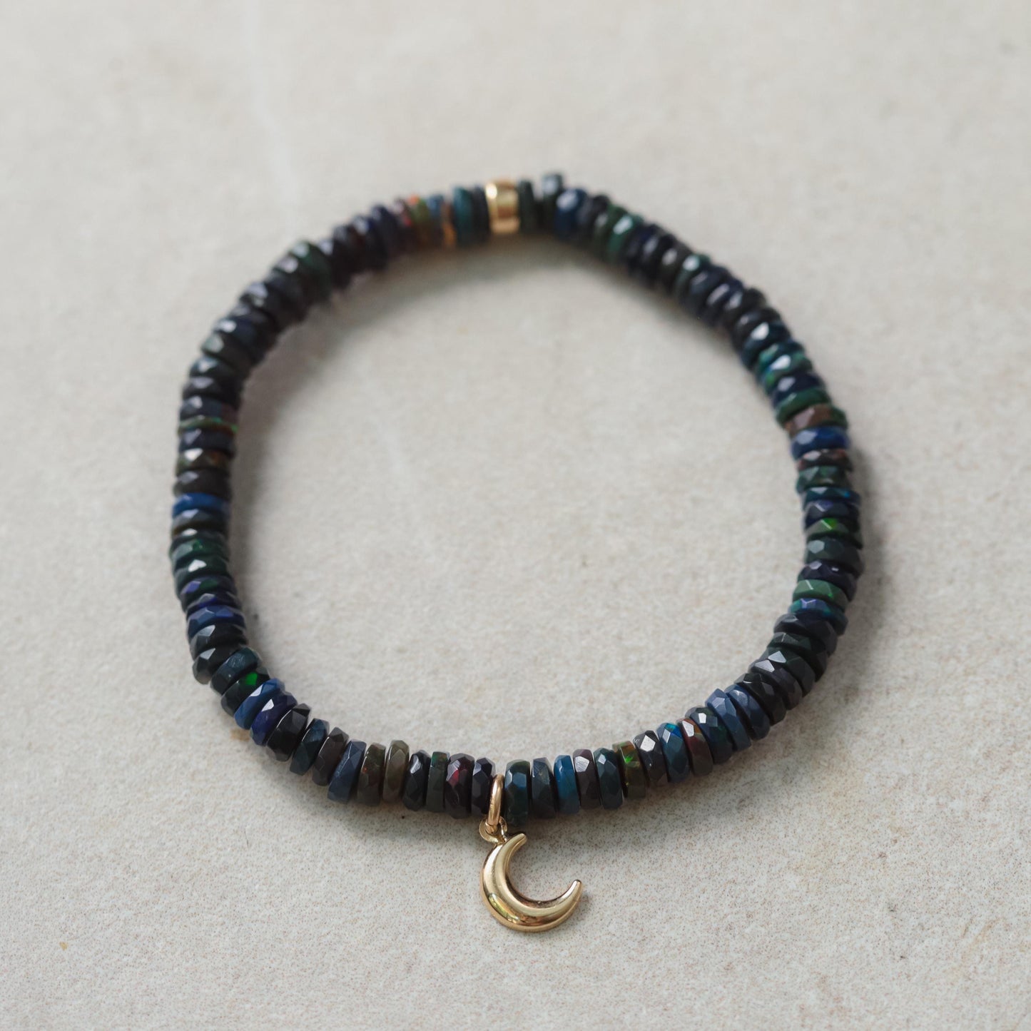 Black Opal Moon Bracelet in 14K gold with moon-shaped charms, featuring colorful opal stones on a delicate gold chain.