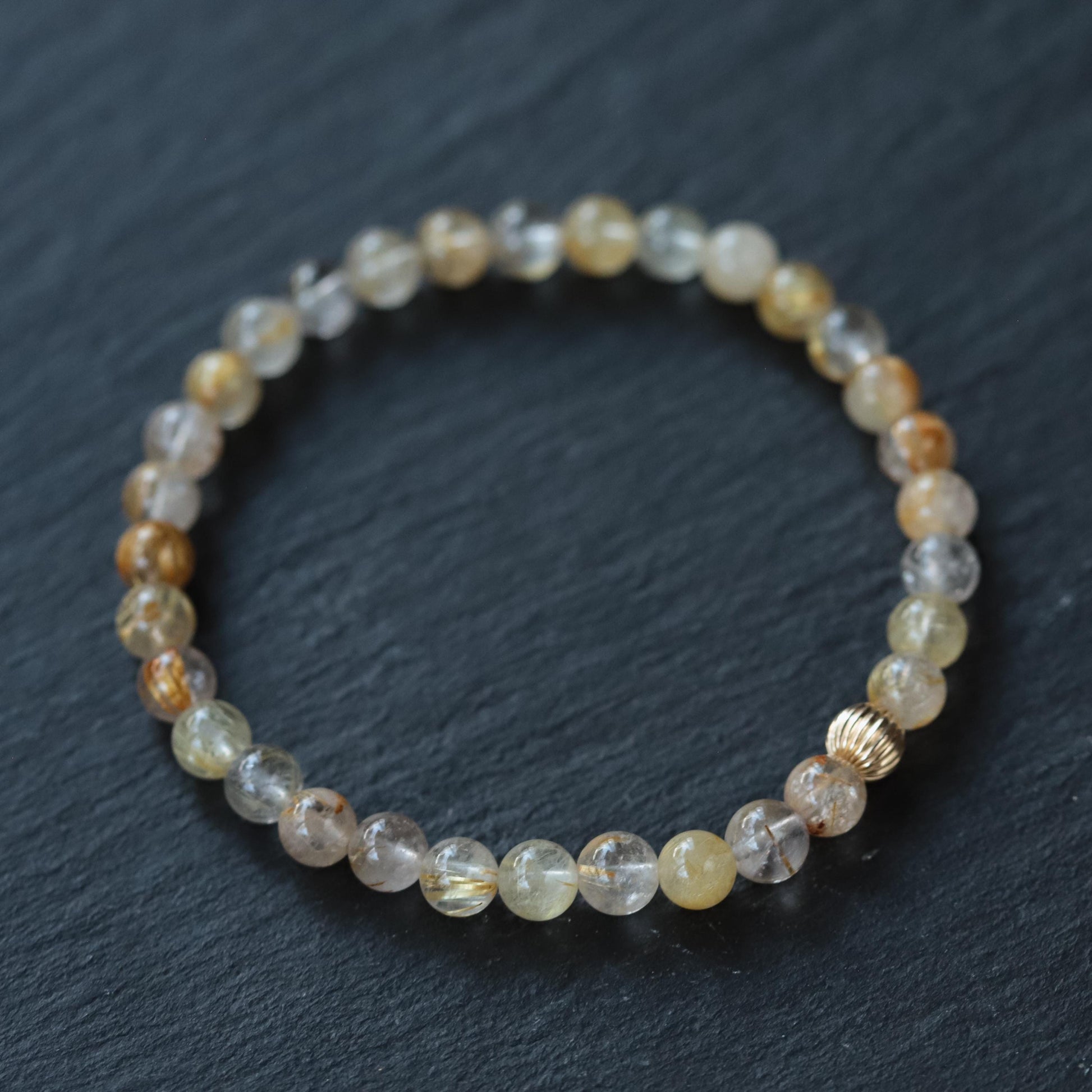 Golden rutilated quartz pendant in 14K gold setting, showcasing vibrant golden rutile inclusions and polished finish.