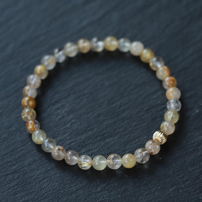 Golden rutilated quartz pendant in 14K gold setting, showcasing vibrant golden rutile inclusions and polished finish.