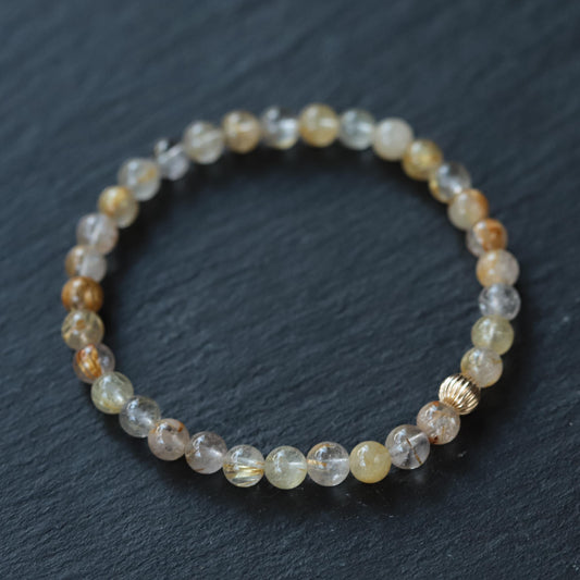 Golden rutilated quartz gemstone pendant in 14K gold setting, showcasing golden rutile inclusions and polished surface.