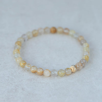 Golden rutilated quartz gemstone set in 14K gold, featuring golden needle inclusions, from Earthly Abundance.