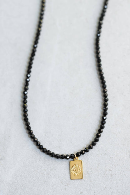 Black tourmaline evil eye necklace with protective pendant on a chain, by Earthly Abundance.