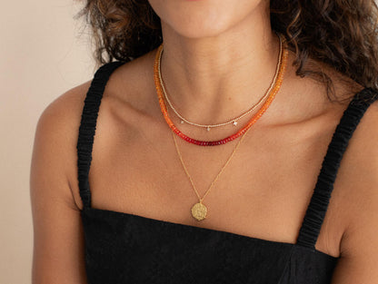 Greek style pendant necklace featuring intricate design on a chain, by Earthly Abundance, displayed against a neutral background.