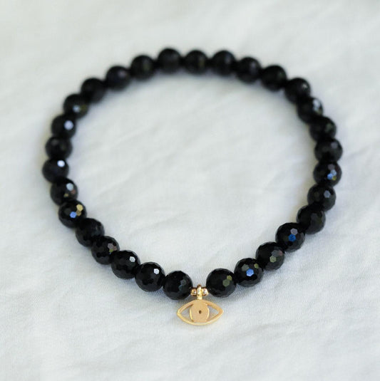Black Tourmaline Evil Eye pendant from Earthly Abundance featuring protective evil eye charm and polished black gemstone.