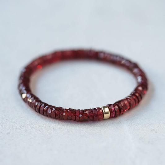 Earthly Abundance garnet heishi bracelet featuring small red gemstone beads on an elastic band, natural jewelry accessory.