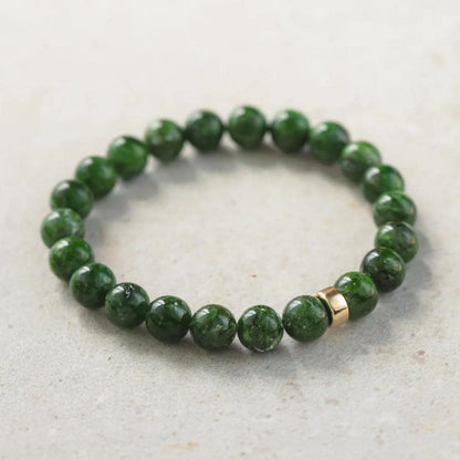 Chrome dioptase gemstone in 14K setting, showcasing vibrant green mineral with intricate natural patterns.