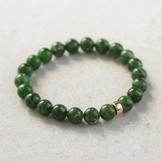 Chrome dioptase gemstone in 14K setting, showcasing vibrant green mineral with intricate natural patterns.