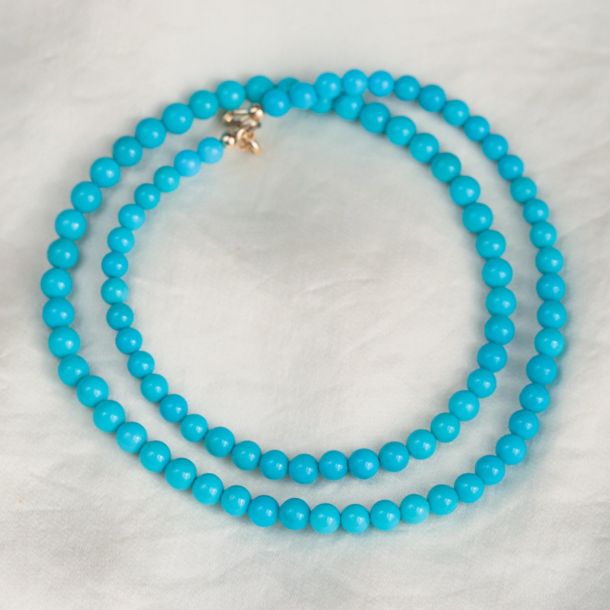 Sleeping Beauty turquoise 4.5-5mm beads on a 14K setting, featuring vibrant blue stones in a jewelry piece by Earthly Abundance.