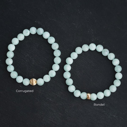 Pectolite gemstone pendant in 14K gold setting, showcasing a smooth, polished light blue mineral with natural veining.