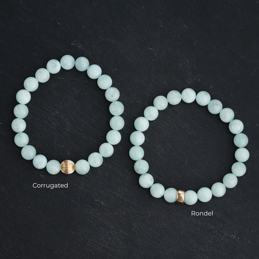 Pectolite gemstone pendant in 14K gold setting, showcasing a smooth, polished light blue mineral with natural veining.
