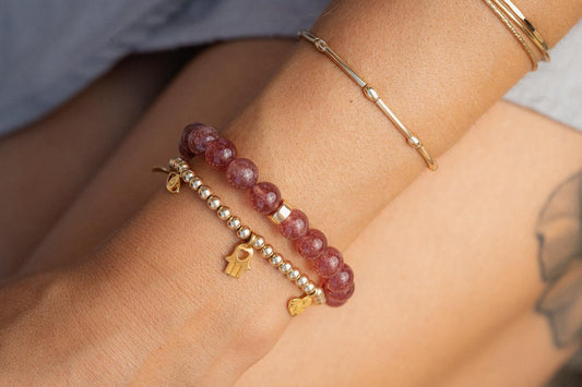 Strawberry quartz pendant set in 14K gold, featuring a vibrant pink gemstone with gold accents.
