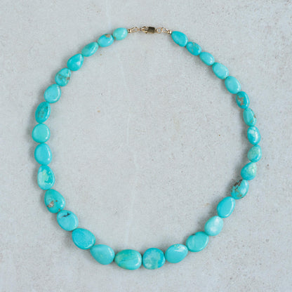 Turquoise Sol Necklace in 14K gold from Earthly Abundance featuring a vibrant turquoise pendant on a delicate gold chain.