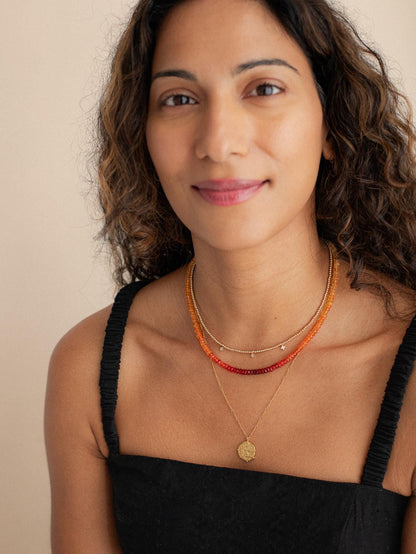 Mexican fire opal necklace with 14K gold setting, featuring vibrant orange-red gemstones on a delicate chain.