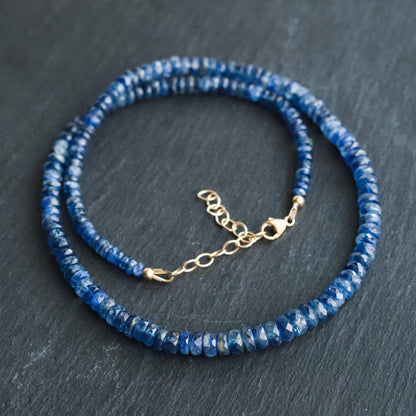 Kyanite necklace with polished blue stones on a delicate silver chain, worn as a jewelry accessory.