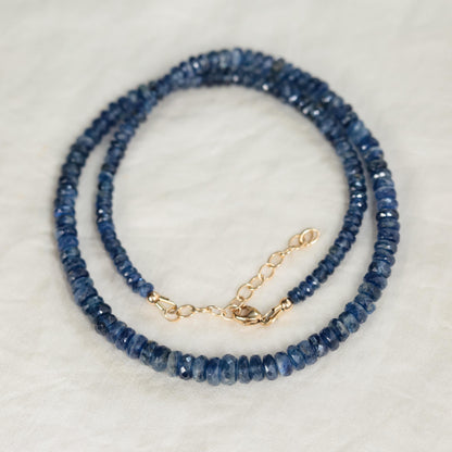 Kyanite necklace with a polished blue gemstone pendant on a silver chain, displayed against a neutral background.
