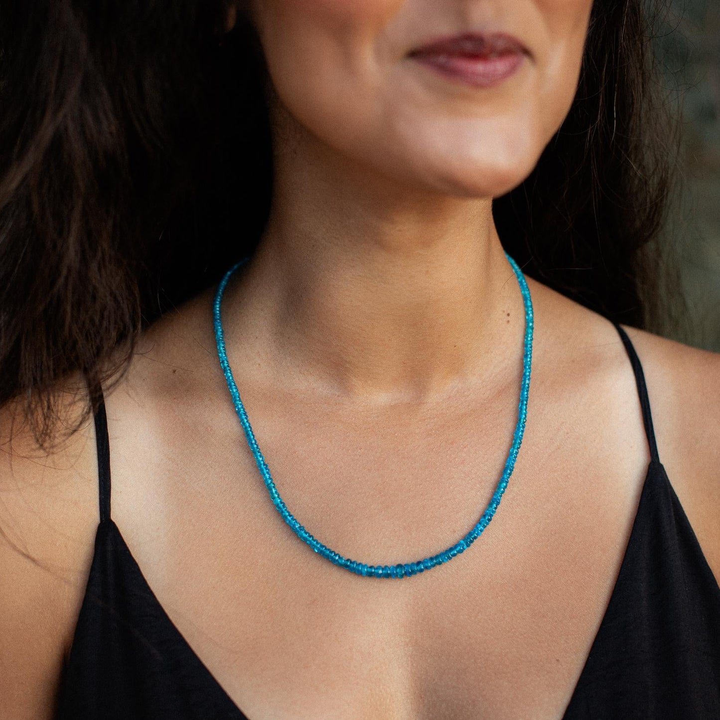 A Gemmy Apatite necklace featuring a vibrant blue-green gemstone pendant on a silver chain, displayed against a neutral background.