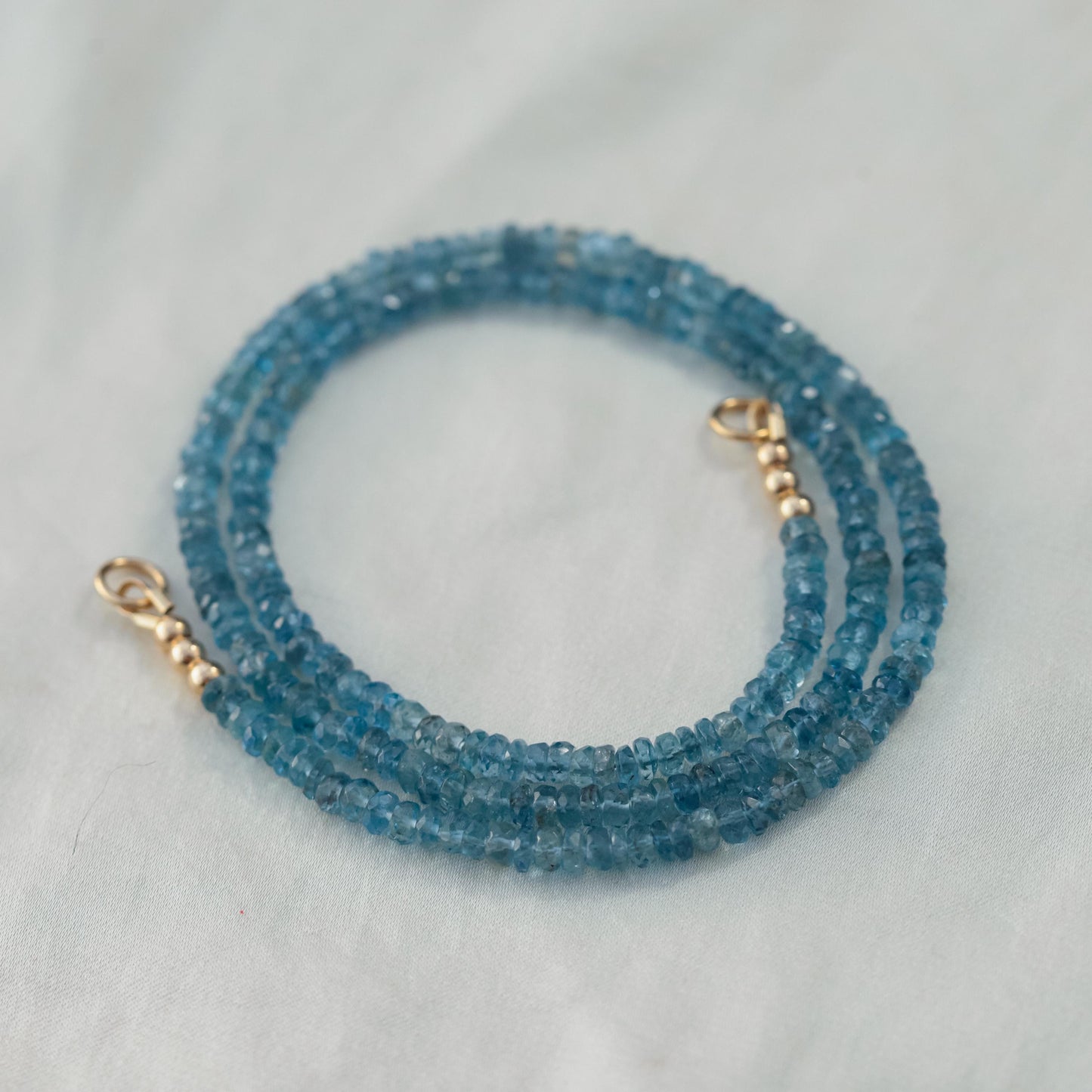 Santa Maria aquamarine drop carabiner clip by Earthly Abundance, featuring a vibrant aquamarine gemstone and metal clasp.
