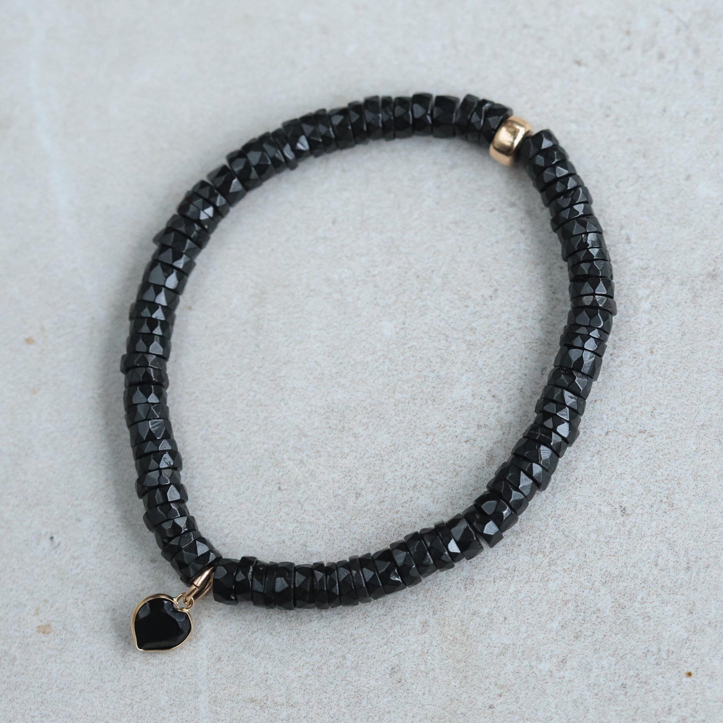 Black spinel heart bracelet with 14K gold accents, showcasing elegant jewelry design by Earthly Abundance.