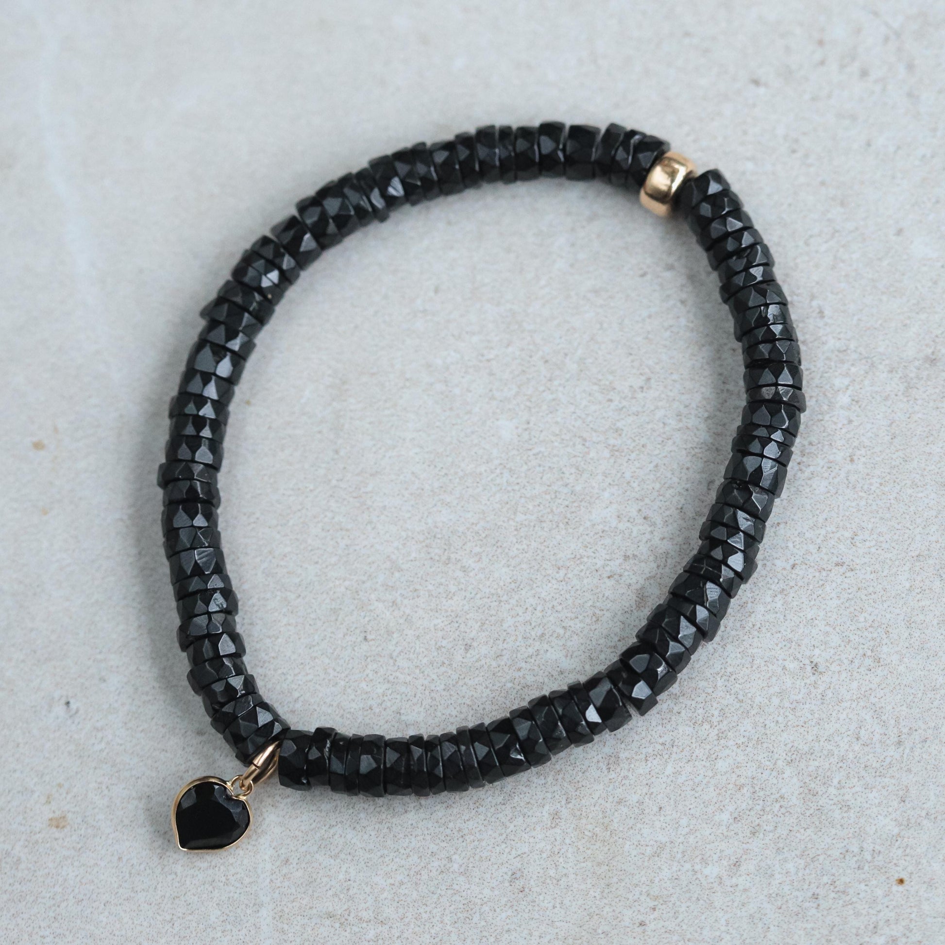 Black spinel heart bracelet with 14K gold accents, showcasing elegant jewelry design by Earthly Abundance.