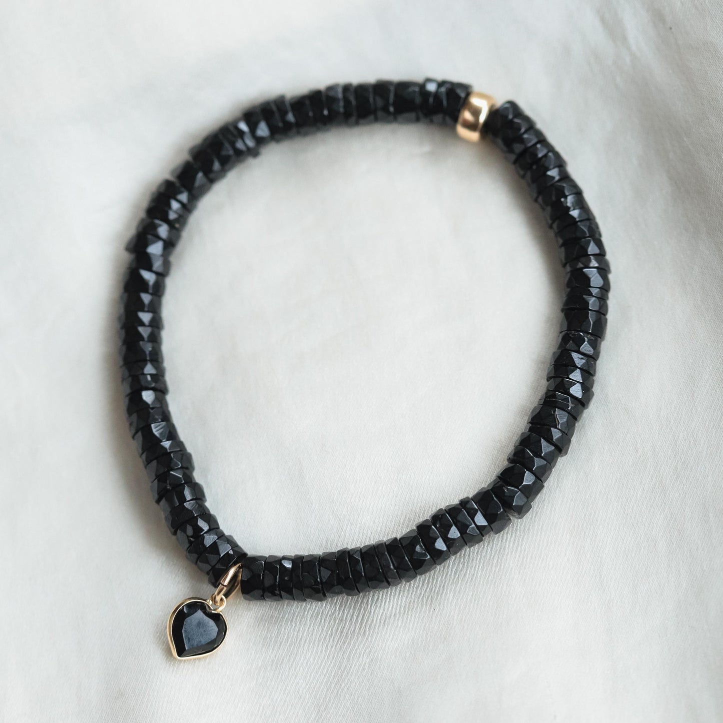 Black spinel heart bracelet with 14K gold accents from Earthly Abundance, featuring a delicate chain and heart-shaped black spinel charms.