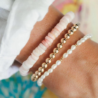 Pink Opal Heishi bracelet featuring small, smooth pink opal beads on a stretchy cord, handcrafted by Earthly Abundance.