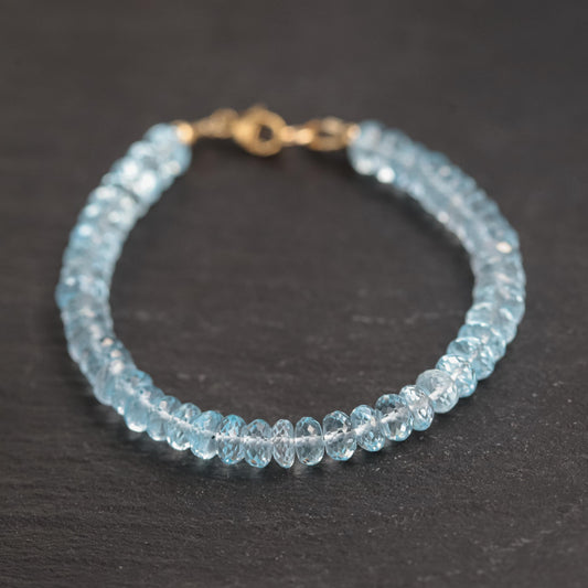Swiss Blue Topaz bracelet featuring 14K gold setting with sparkling blue gemstones on a delicate chain.