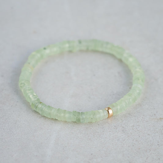 Prehnite beaded bracelet featuring smooth green stones from Earthly Abundance, close-up of the jewelry on white background.