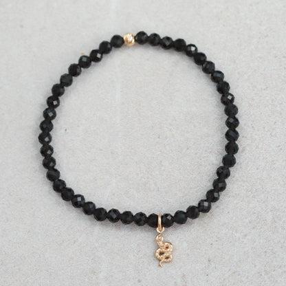 Obsidian snake bracelet crafted with 14K gold from Earthly Abundance, featuring a detailed snake design on a sleek black obsidian band.